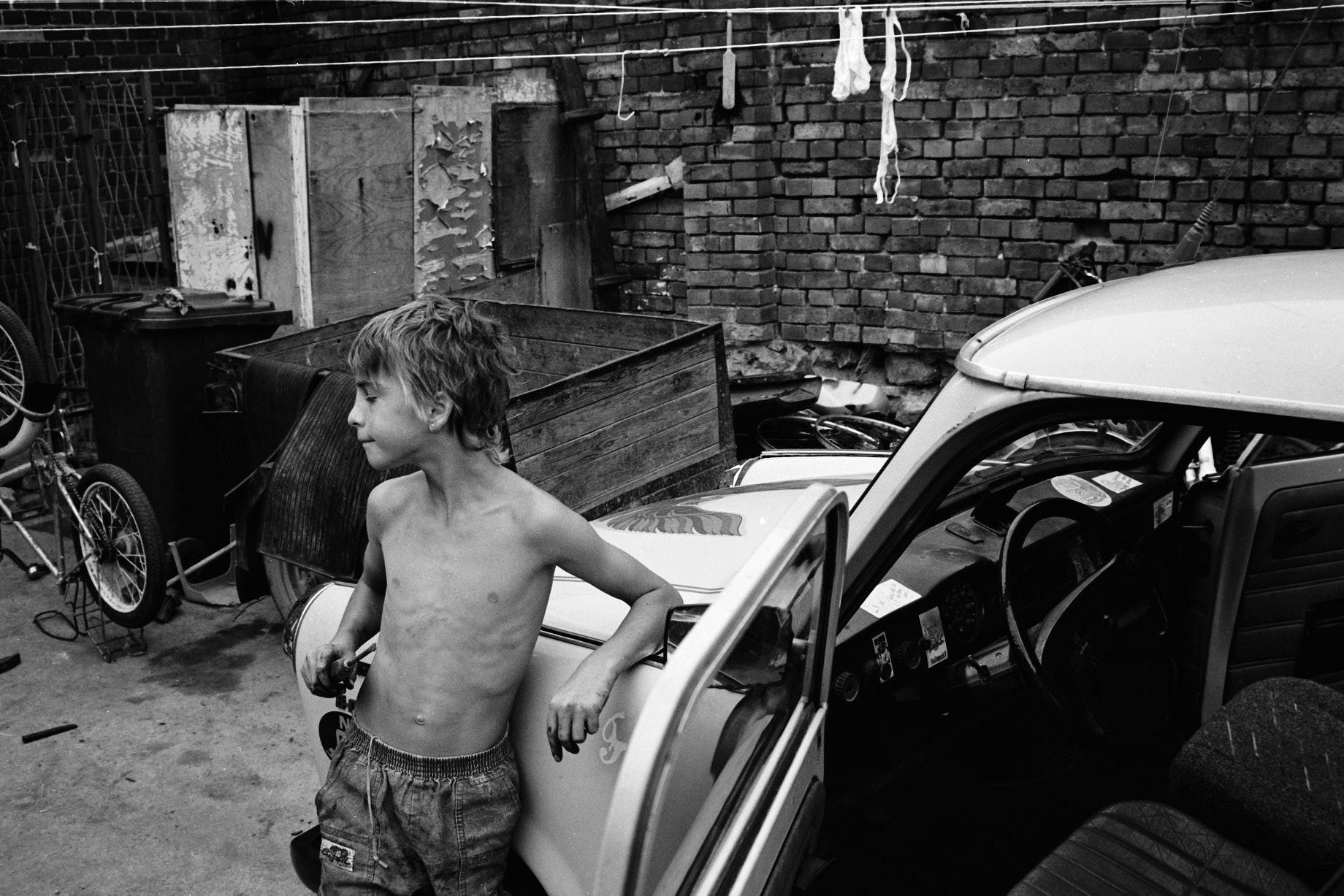 Junge mit Schraubenzieher neben einem Trabant. - Foto: Thomas Steinberg