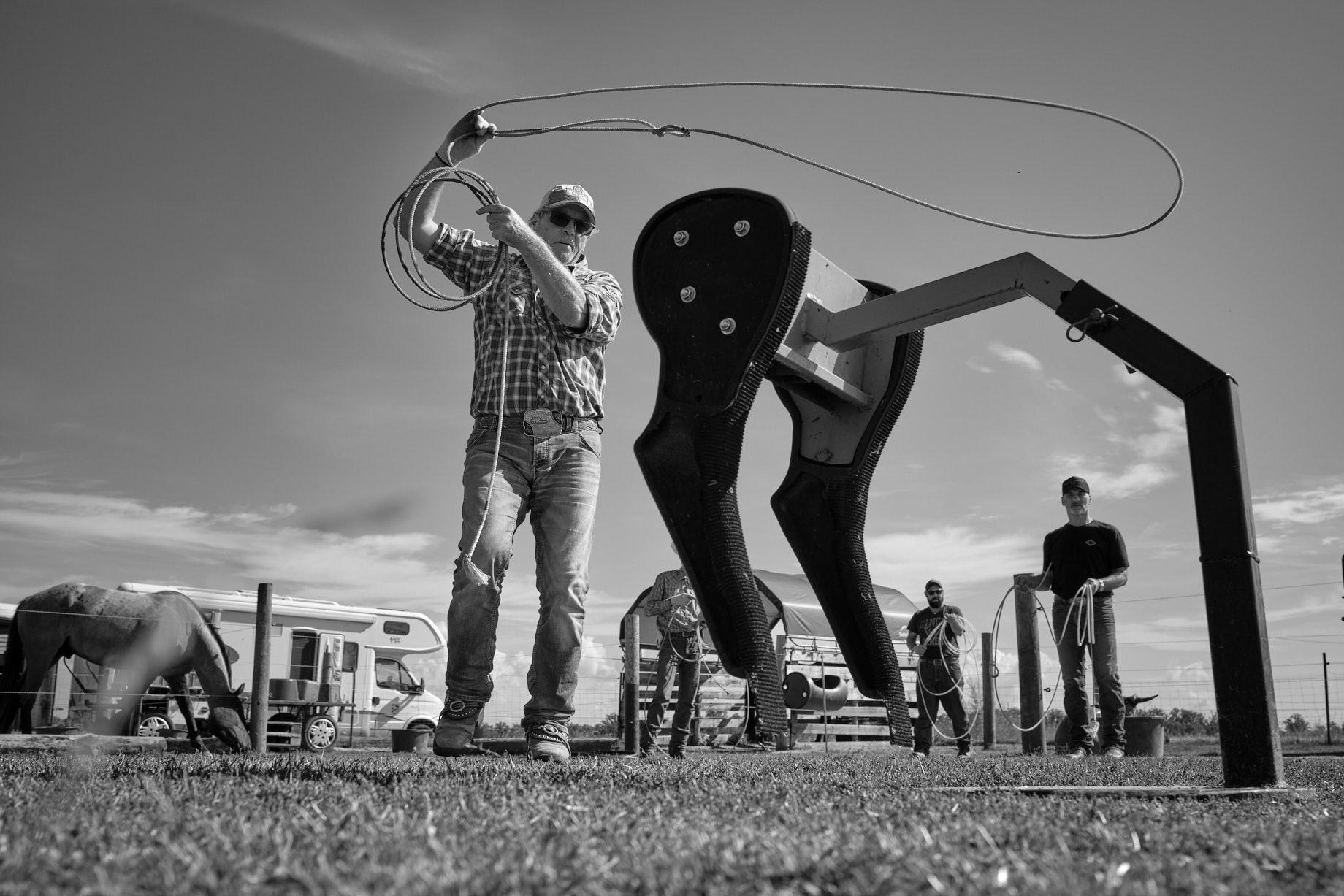 Mann schwingt Lasso &uuml;ber dem Kopf. Im Vordergrund die stark vereinfacht Attrappe eines Kalbs. - Foto: Thomas Steinberg