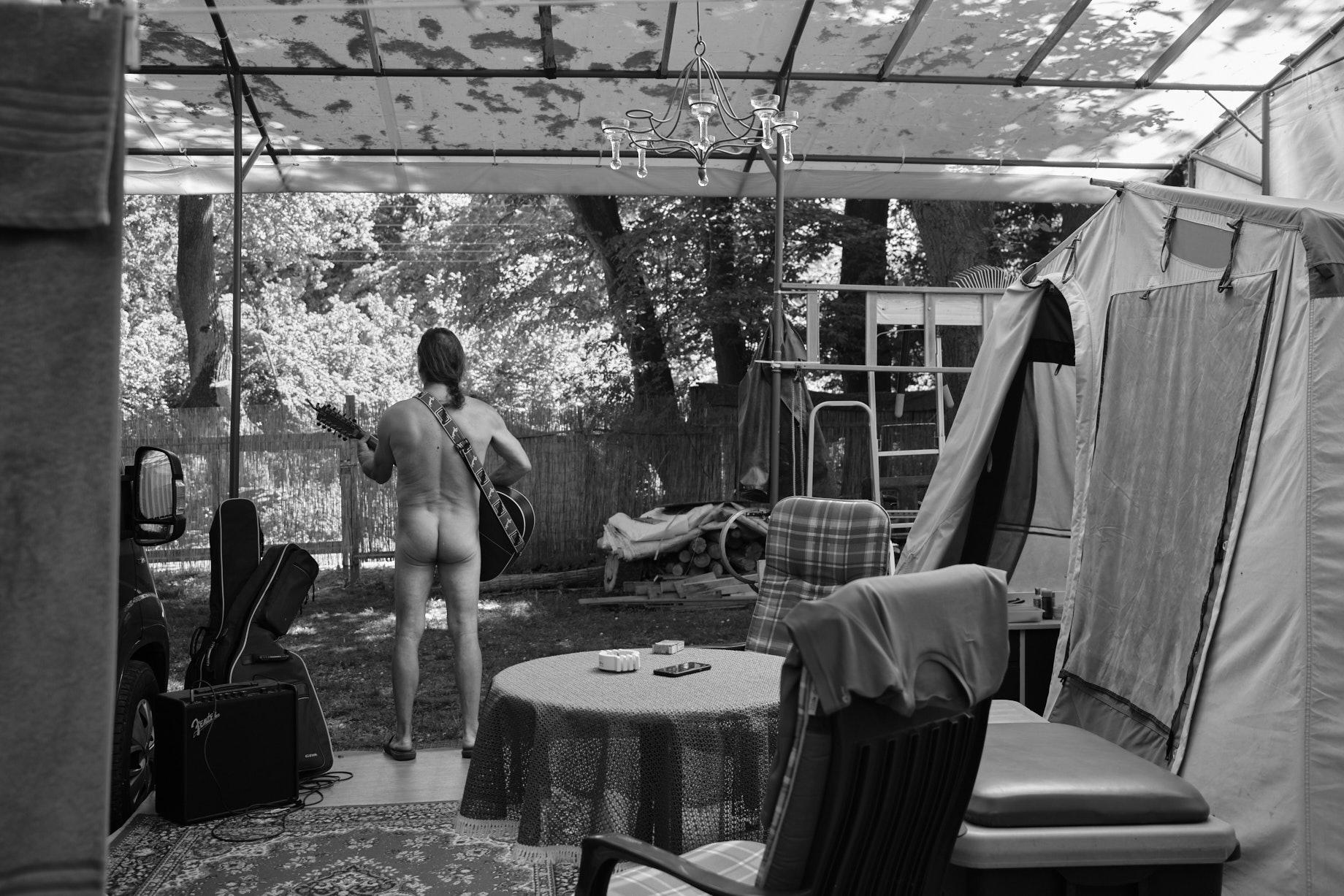 Ein nackter Mann &uuml;bt im Freien Gitarre - Foto: Thomas Steinberg